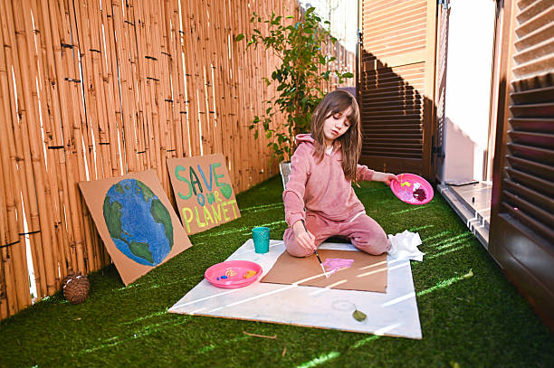 Child painting environmental protest signs on balcony