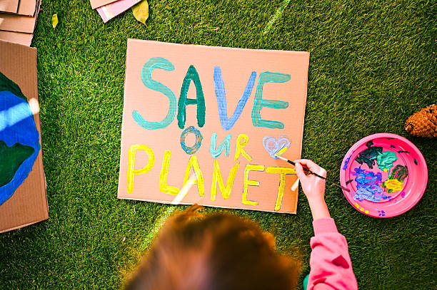 istock Child painting save our planet sign for environmental protest 2240766890