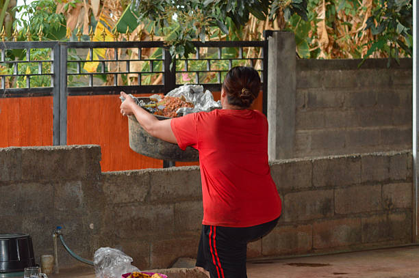 istock Woman carrying peanut shell trash bin and placing on wall 2240771723