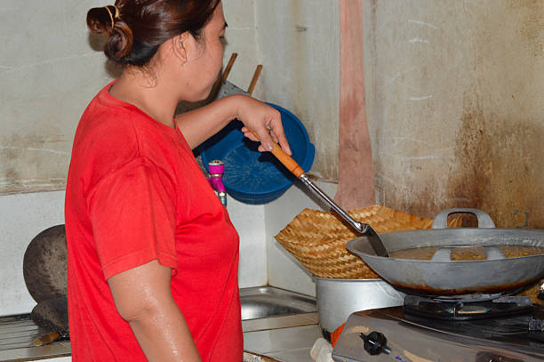 istock Woman stirring frying peanuts with a ladle in home kitchen 2240771765