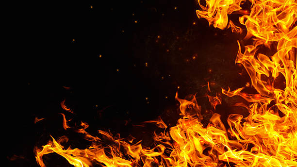 istock Dramatic red, orange, yellow flame and smoke rising against a dark background. Realistic, abstract fire burning background texture overlay. Vivid and hot hell or blazing fire wallpaper 2240771780