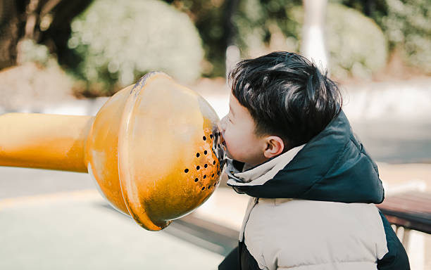 Little Asian boy playing happily alone in the park amusement park