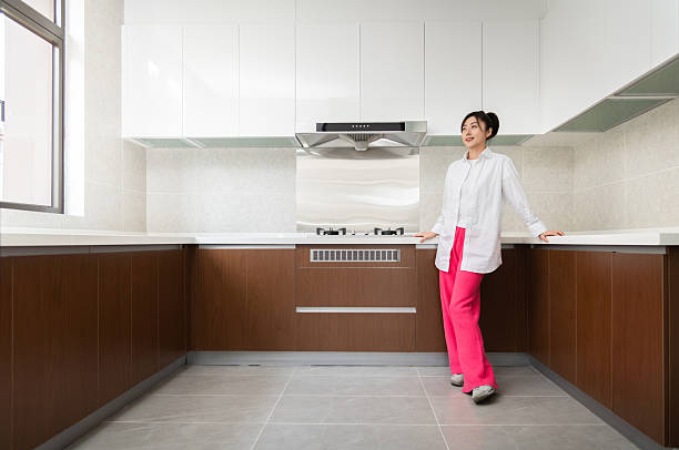Smiling young woman standing in her kitchen