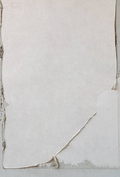 istock Weathered and torn ads poster old paper on cement wall. Abstract grunge 2240776617