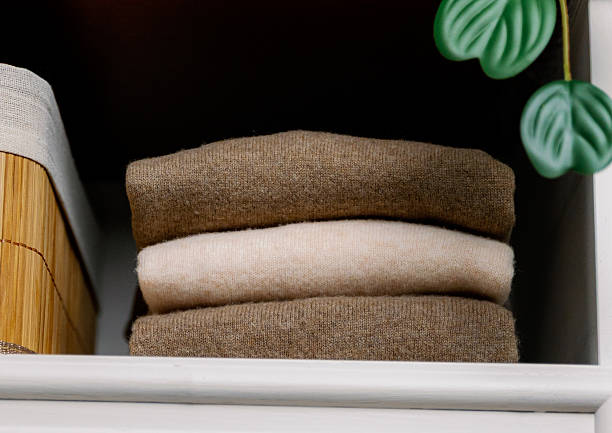 istock Stylish wool sweaters on a shelf in the closet. 2240776796