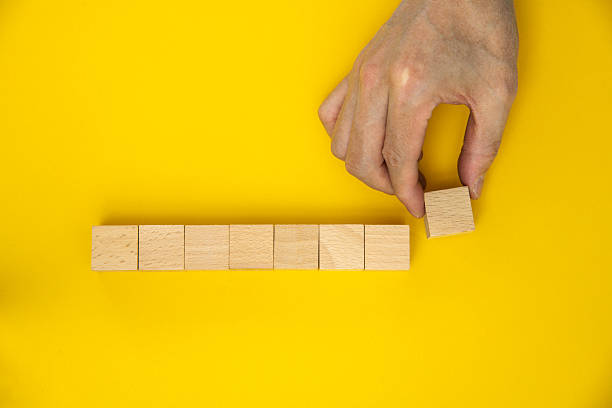 istock Hand lined up eight wooden blocks free space to work 2240777574