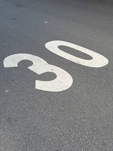 Speed limit 30 sign on wet asphalt, symbol
