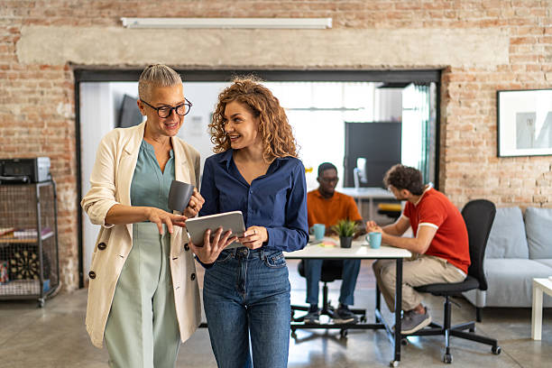 istock Businesswomen collaborating on tablet during office coffee break 2240780381