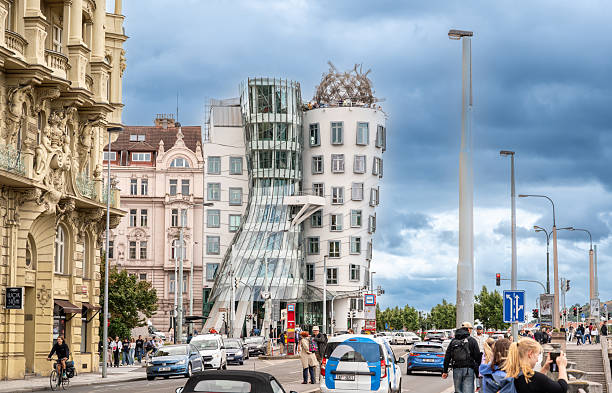 Prague, Czech Republic, August 7, 2023. Fascinating side view of the Dancing House: futuristic shapes and modern materials. People in the street. Travel destinations.