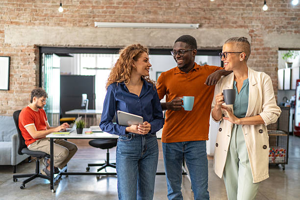 istock Diverse coworkers talking and smiling during office break 2240780972