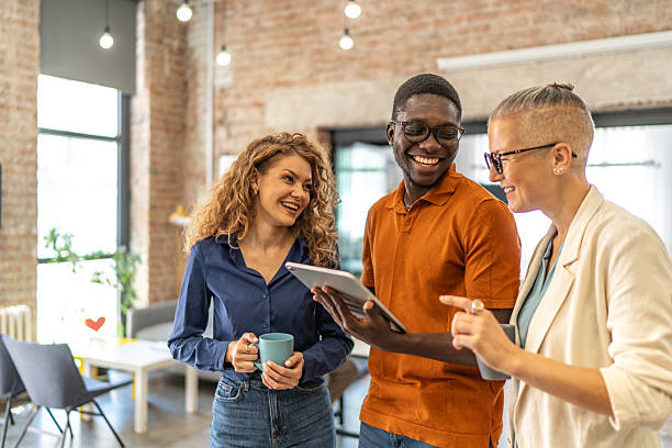 Diverse business team collaborating in modern office with digital tablet