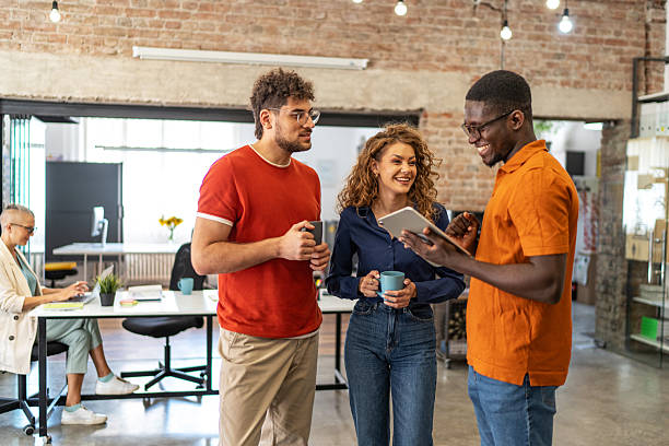 istock Colleagues collaborating during coffee break in modern office 2240781139