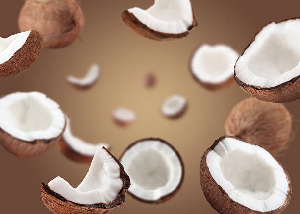 istock Coconuts swirling in air against pale brown background 2240785659