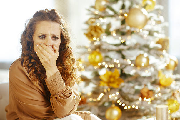 istock Woman\'s Distressed Holiday Reaction by Christmas Tree 2240785699