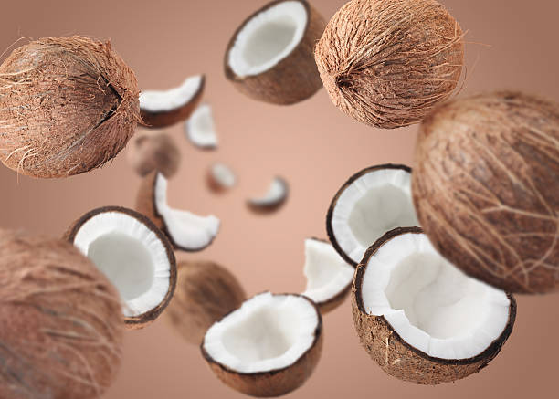 istock Coconuts swirling in air against pale brown background 2240785797