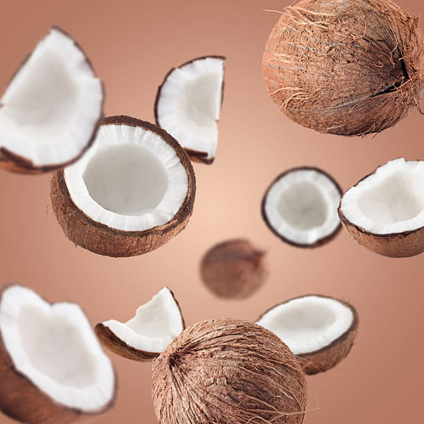 istock Coconuts swirling in air against pale brown background 2240786076
