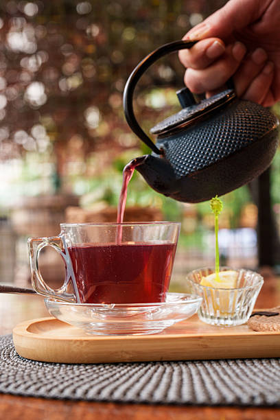 istock Pouring Herbal Red Tea from Cast Iron Teapot 2240790885