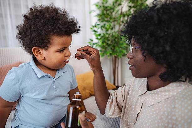 istock Pediatric nurse checking child's throat during home visit 2240792308