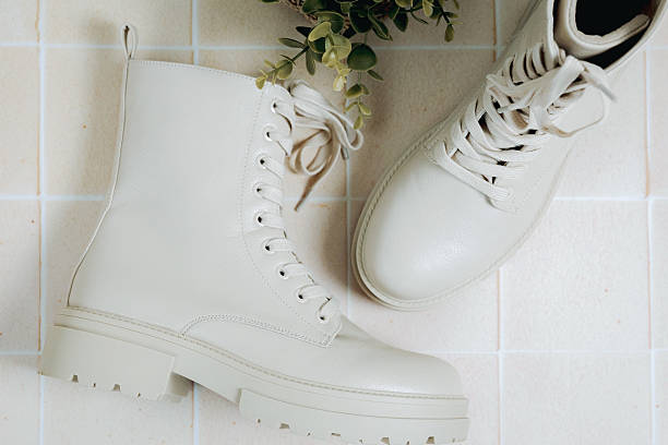 istock Beige boots on a tiled floor with a green flower. 2240793380