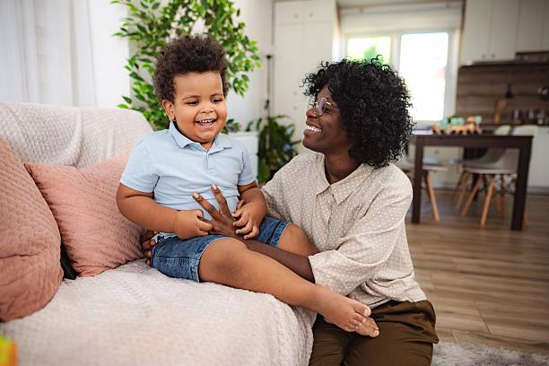 istock Pediatric nurse tickling smiling boy during home care 2240793554