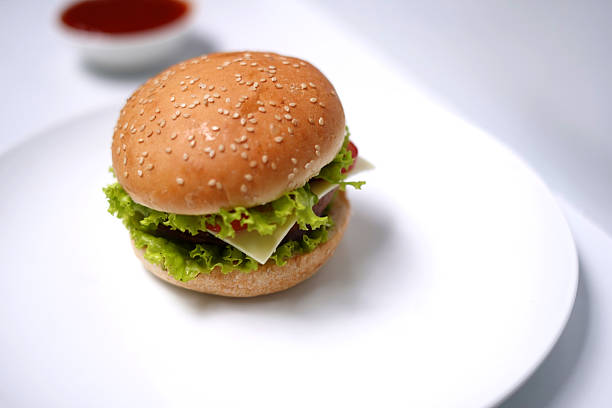 Hamburger with tomato and lettuce on white background.