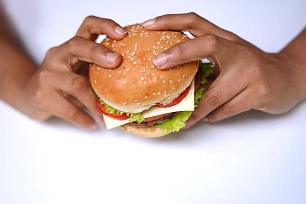 Before first bite hands holding hamburger on white background. food photography.