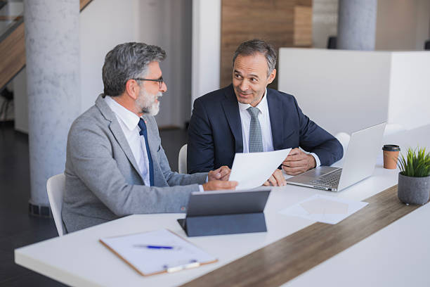 istock Businessmen discussing documents during office meeting 2240796666