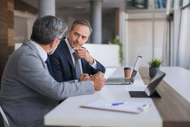 istock Businessmen discussing documents during an office meeting 2240796671