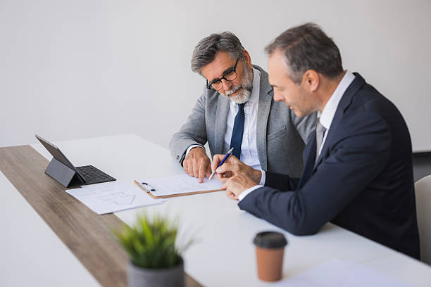 istock Businessmen signing contract during office meeting 2240796700