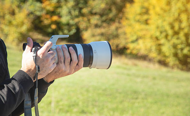 istock Photographer holding a digital camera taking pictures in nature. 2240797113