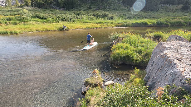 istock Brother and sister paddle  SUP board on river 2240797462