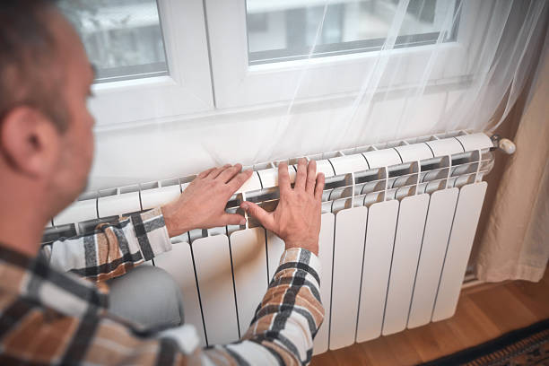 istock Man heating on a chilly winter day, energy and gas crisis, cold room, heating problems. 2240798906