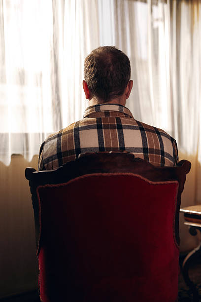 istock Man with depression sitting on a chair at home. 2240799047