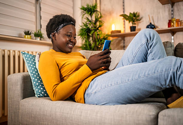 istock Young woman relaxing on sofa texting with mobile phone 2240799208