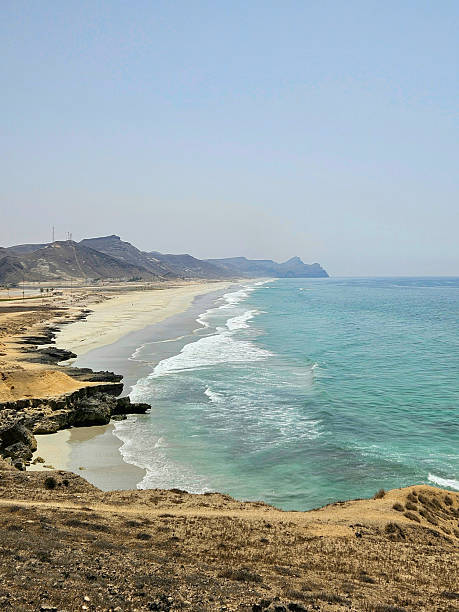istock Panoramic sandy beach with turquoise surf and rocky ledges 2240799427