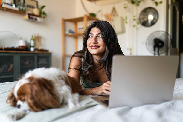 istock Young woman uses laptop while her dogs are around 2240800937