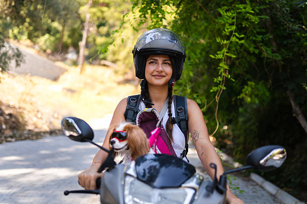 Young woman rides a motorcycle with her dogs