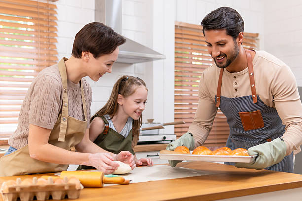 istock Smiling family baking fresh homemade bread together in a modern kitchen 2240804481