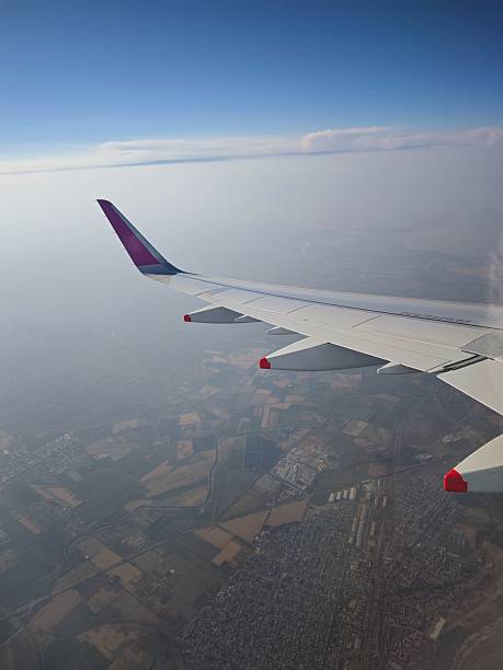 istock Airplane Wing Above the Earth and Blue Sky View 2240807597