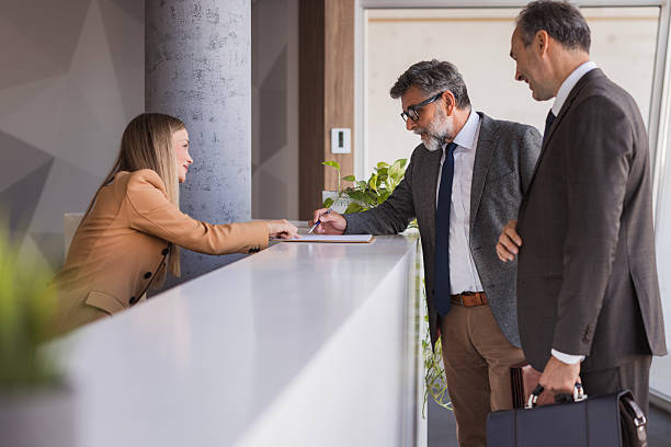 istock Businessmen signing documents at hotel reception desk 2240808193