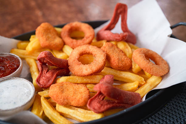 A hearty snack combo featuring crispy fries, golden onion rings, fried sausages, and crunchy cheese bites. Served with ketchup and creamy dipping sauce, perfect for sharing or a quick indulgent treat.