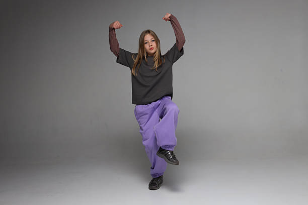 Young caucasian female posing confidently in casual outfit on grey backdrop