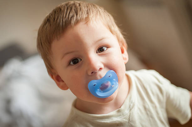 istock Young child with pacifier engages in playful exploration in cozy indoor environment 2240813669