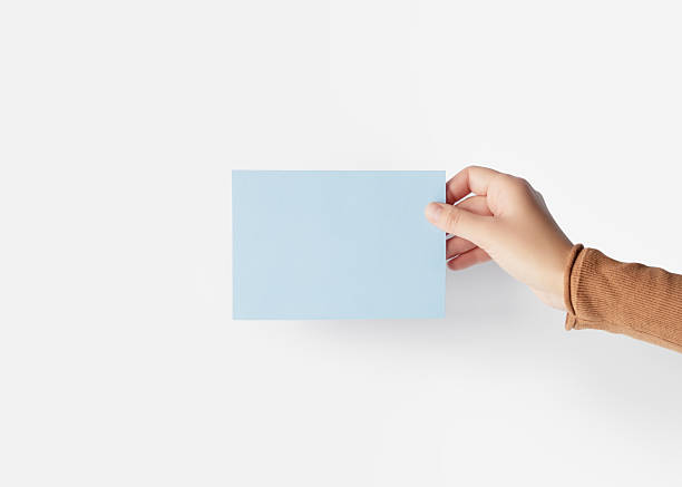 istock Hand holding a blank light blue card on a white background 2240814157
