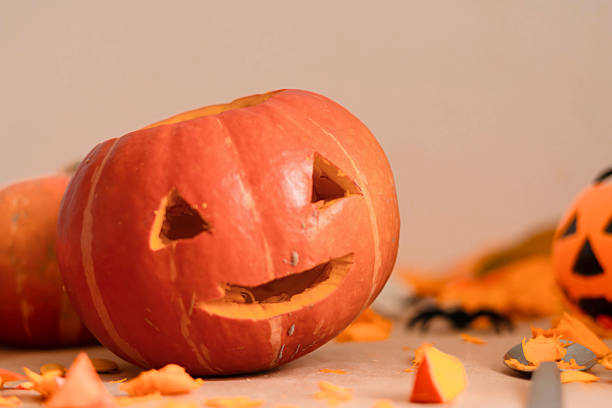 istock Carved Halloween pumpkin with a smiling face on a table 2240814239