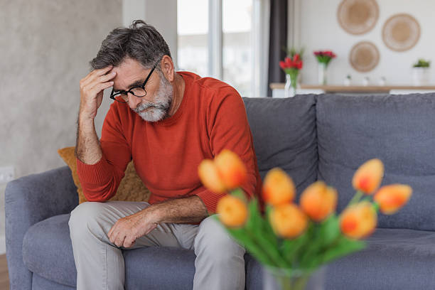 Senior man experiencing headache and stress at home