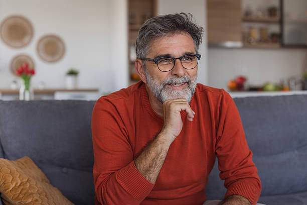 istock Mature man relaxing at home thinking and smiling 2240817661