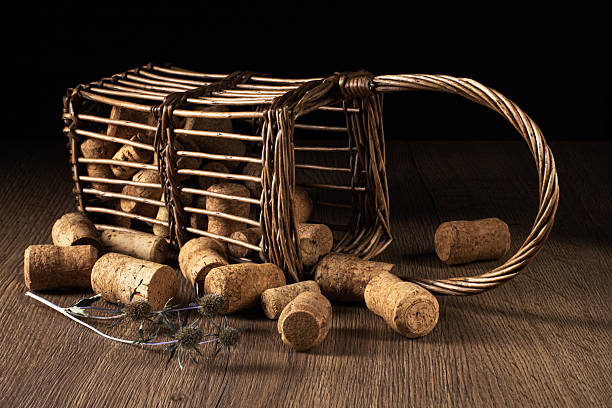 Capture the nostalgia with this captivating image of a retro basket brimming with various corks from wine bottles. The warm hues of the corks contrast beautifully against the inviting wooden table.