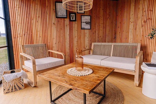 istock Cozy wooden interior with modern armchairs, a rustic coffee table, woven basket, and wall art, showcasing warm Scandinavian decor in natural light. 2240821548