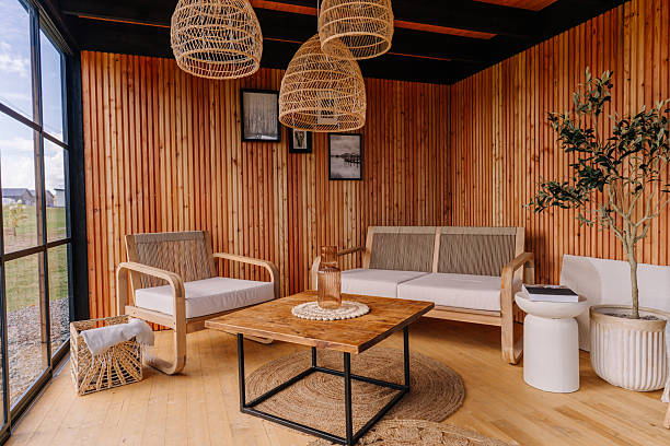 istock Cozy wooden interior with modern armchairs, a rustic coffee table, woven basket, and wall art, showcasing warm Scandinavian decor in natural light. 2240821563